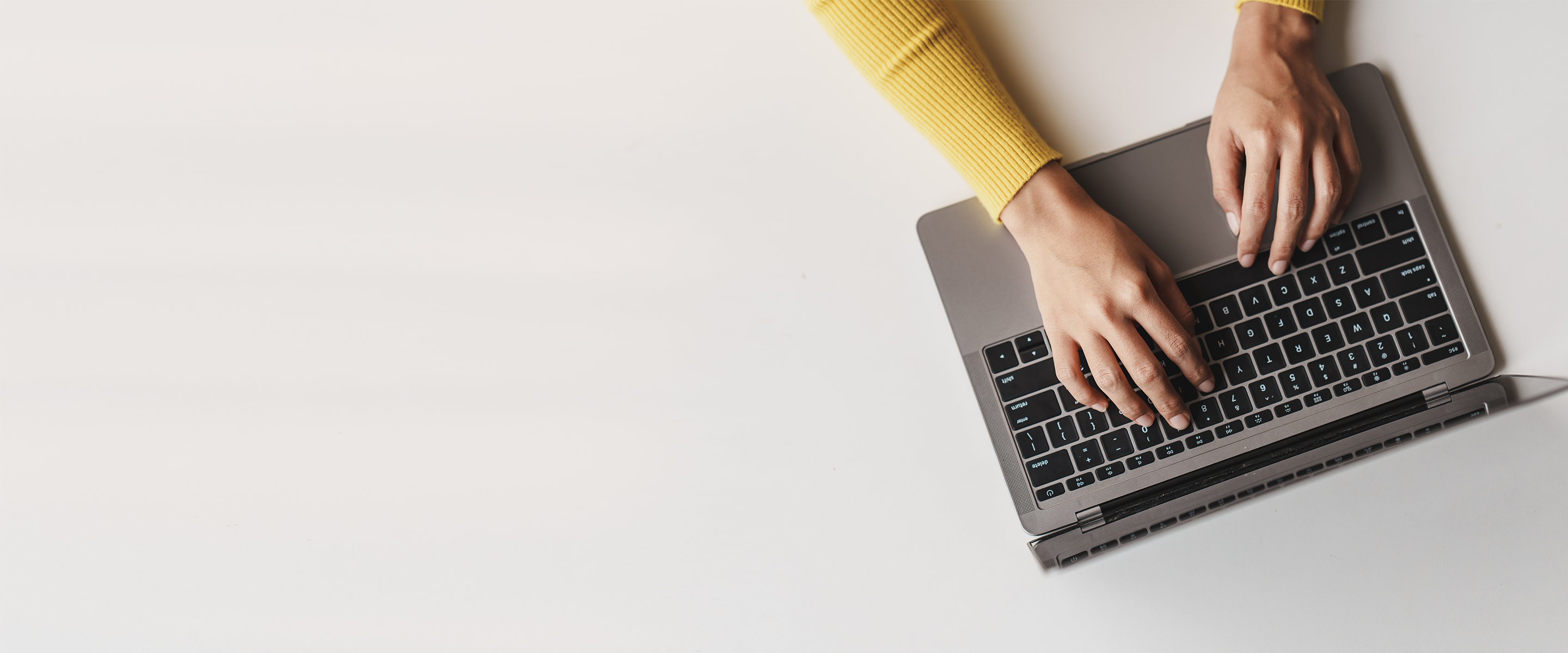 Bird's eye view of a woman typing on a laptop. 