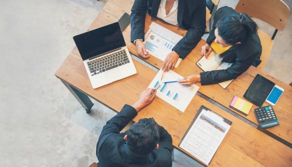Top view of a business meeting at an office desk in a conference room.