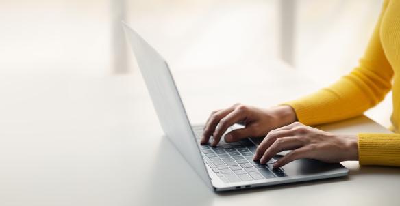 Closeup of a person typing on a laptop