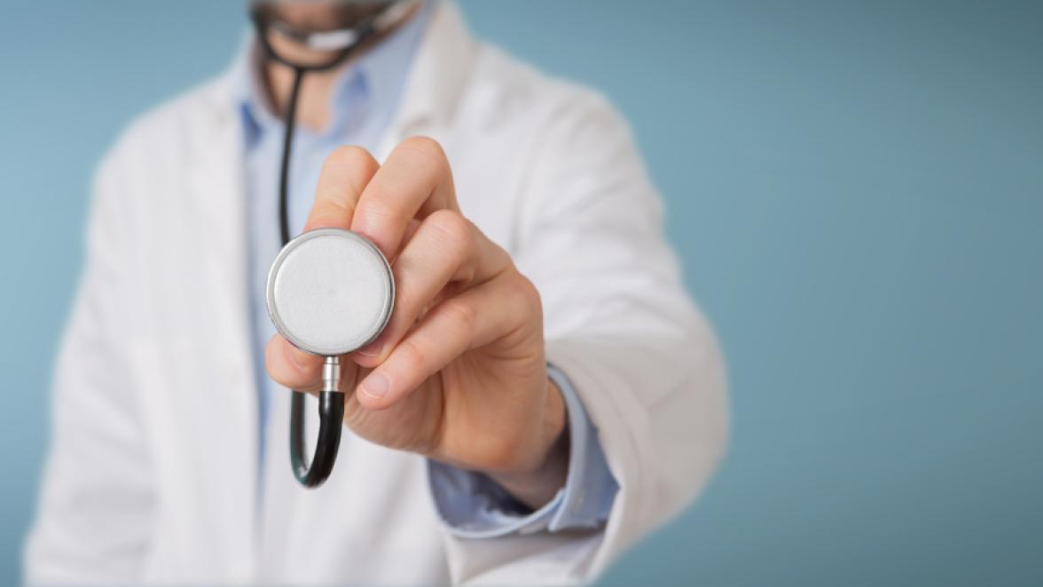 Doctor on blurred background using stethoscope in hospital