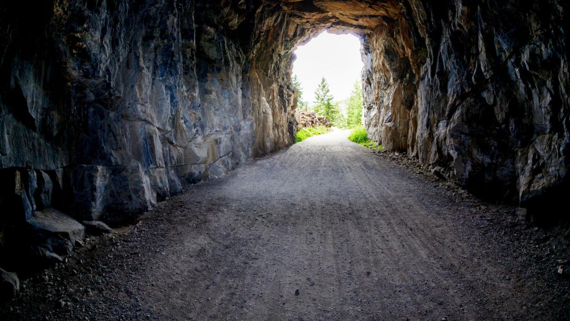 Light at the end of the tunnel at Myra Canyon in Kelonwa, British Columbia, Canada. Concept of conquering adversity or success through obstacles.
