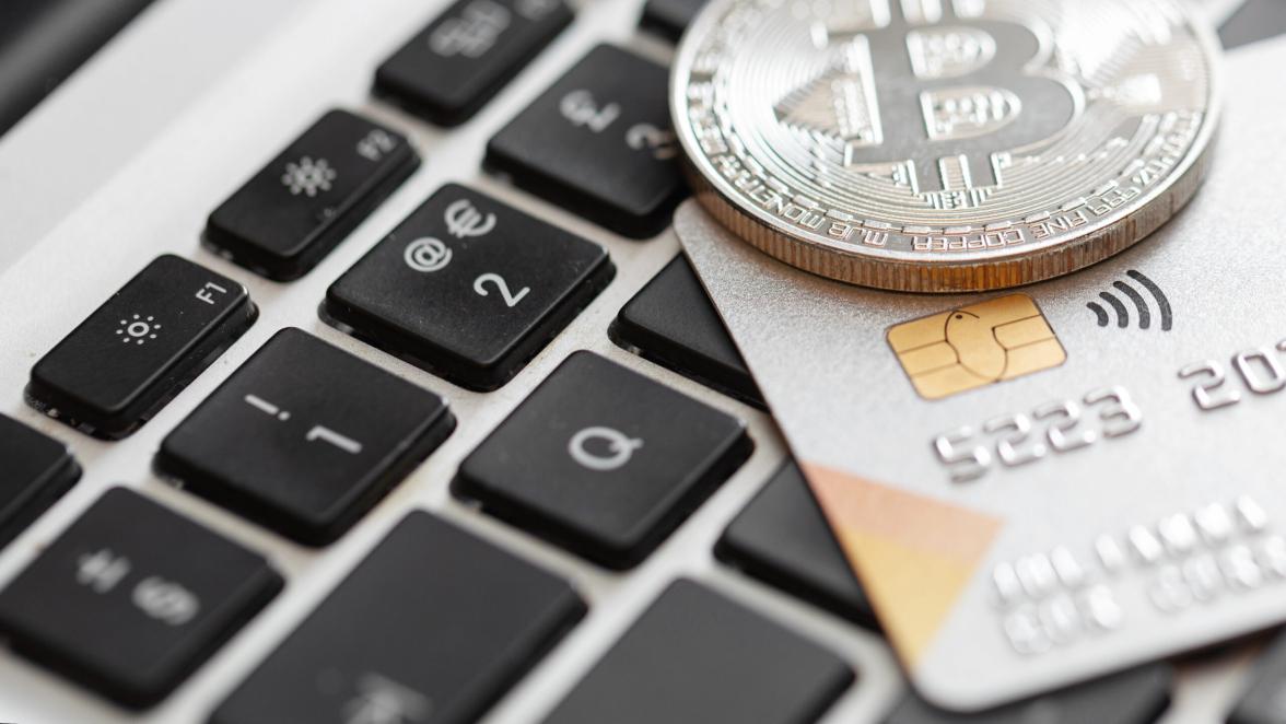 Close-up of credit card and bitcoin on the computer keyboard