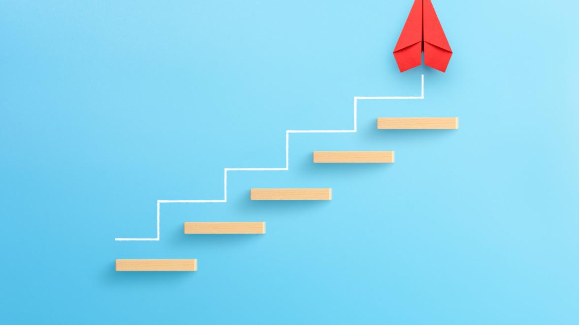wooden-block-stacking-as-step-stair-with-red-paper-plane-on-blue-background-ladder-of-success-in-business-growth-concept-copy-space