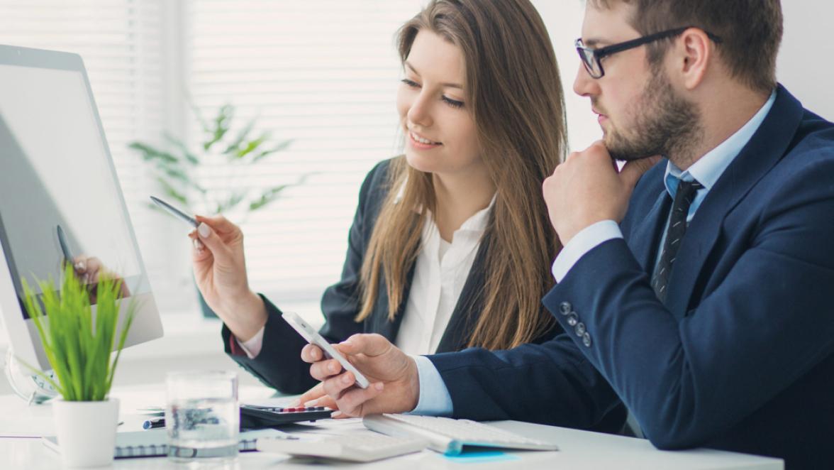 Young businessman discussing something with his colleague, and using a digital tablet together