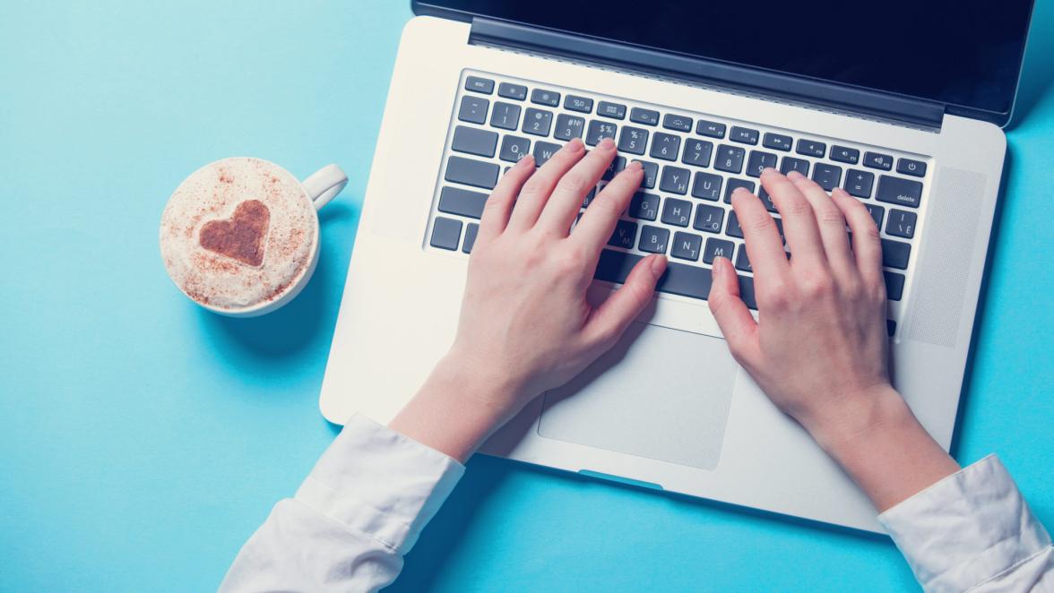 Young woman with notebook and cup of coffee on blue background