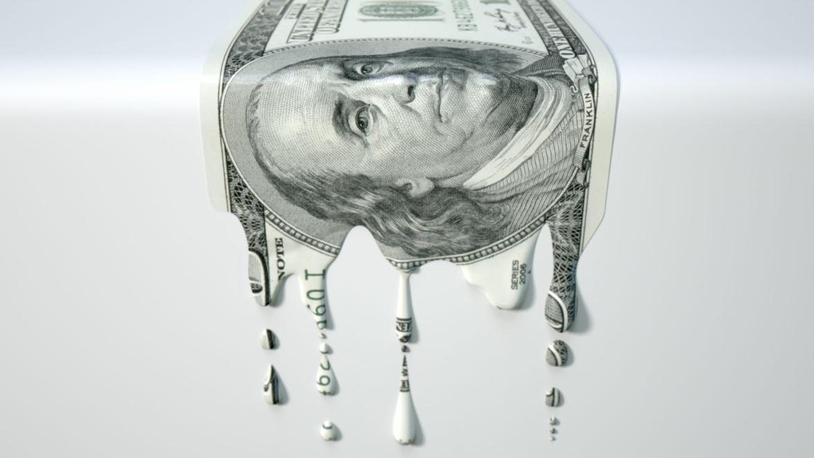 A concept image showing a regular US Dollar banknote that is half melted and liquified dripping on an isolated studdio background