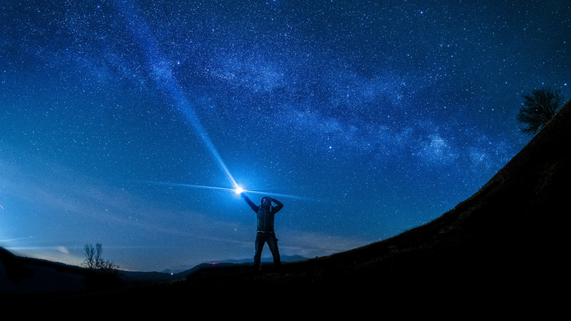 Guide pointing to the starry sky with a flashlight