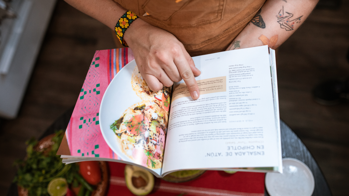 Home cook reading a recipe book