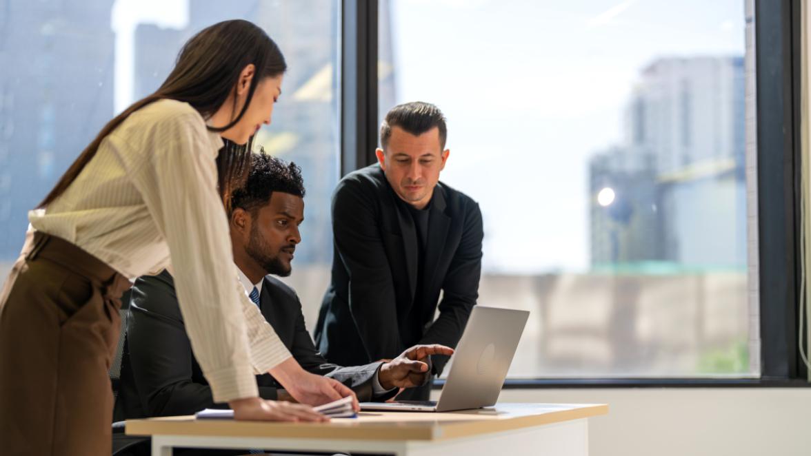 group of professionals looking at a laptop