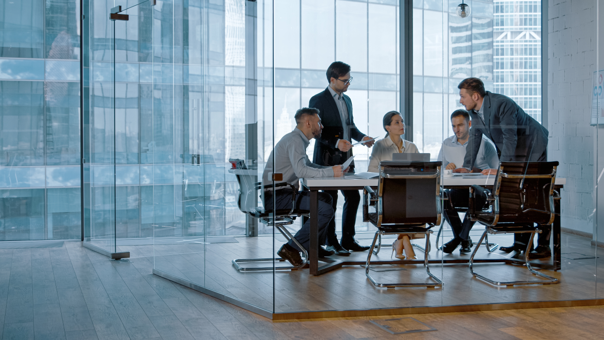 Young professionals have a discussion in a modern office conference room with glass walls