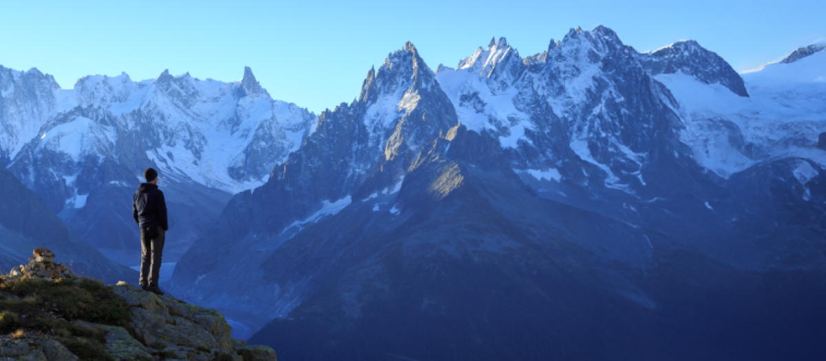 A man looks out at the mountains in France