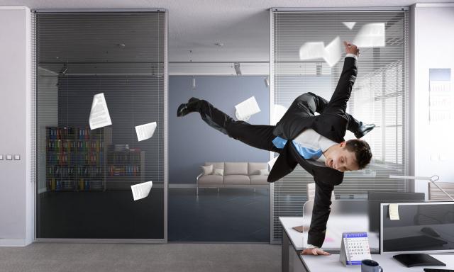 Young cheerful businessman dancing in his office. Mixed media