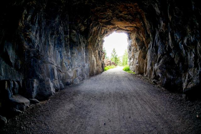 Light at the end of the tunnel at Myra Canyon in Kelonwa, British Columbia, Canada. Concept of conquering adversity or success through obstacles.