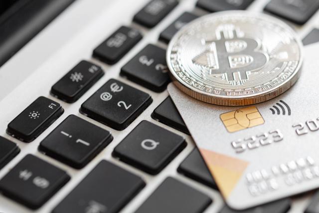 Close-up of credit card and bitcoin on the computer keyboard