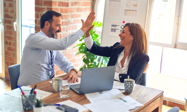 Office workers high-fiving