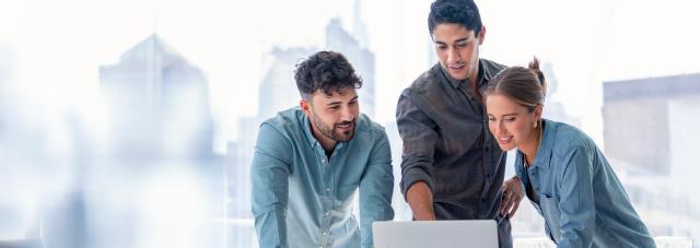 Three colleagues looking at a computer screen