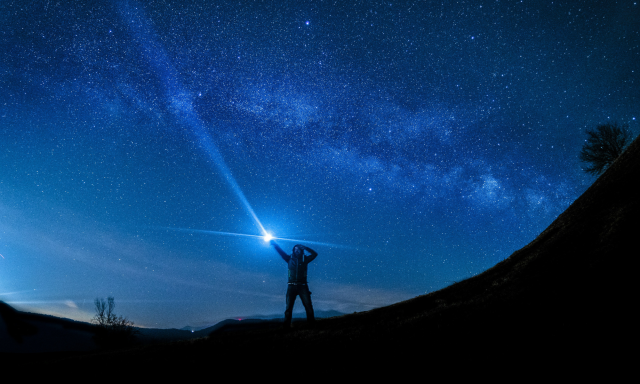 Guide pointing to the starry sky with a flashlight