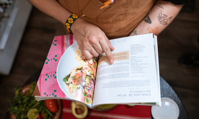 Home cook reading a recipe book