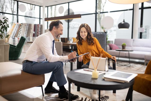 "Interior designer and client reviewing plans together in a modern furniture showroom. 