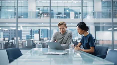 Young professionals meet in a clean, modern office conference room