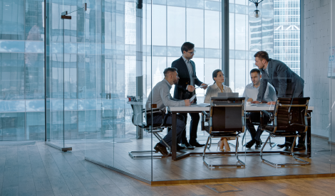 Young professionals have a discussion in a modern office conference room with glass walls