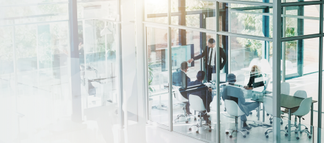 A business presentation in a conference room with glass walls.