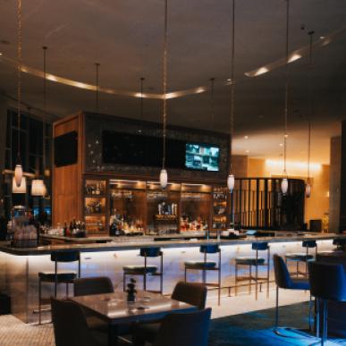 The interior of an empty upscale bar with dim lighting 